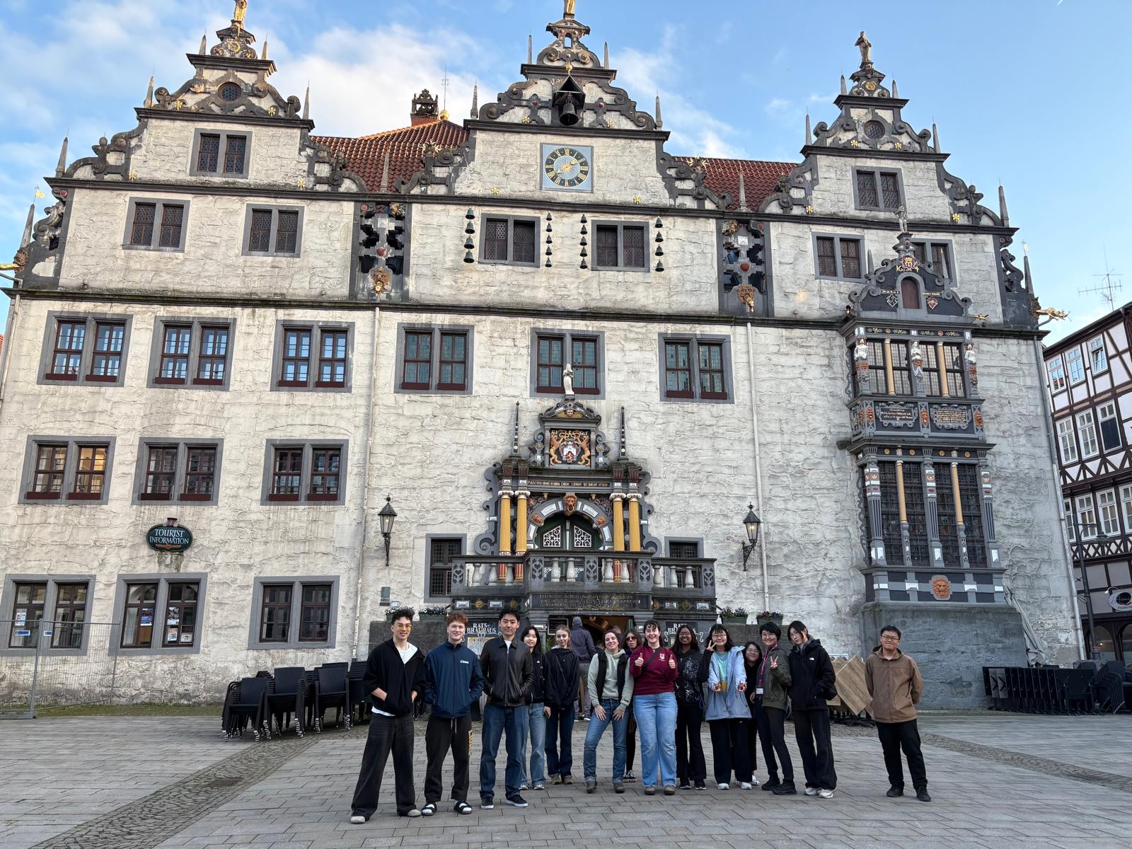 students stand  in front of a historical City Hall in Kassel Germany 