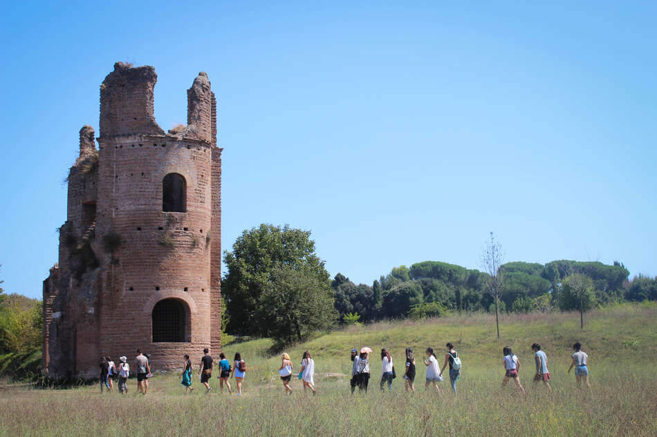 Line of students walking to old building, near Via Appia, Rome