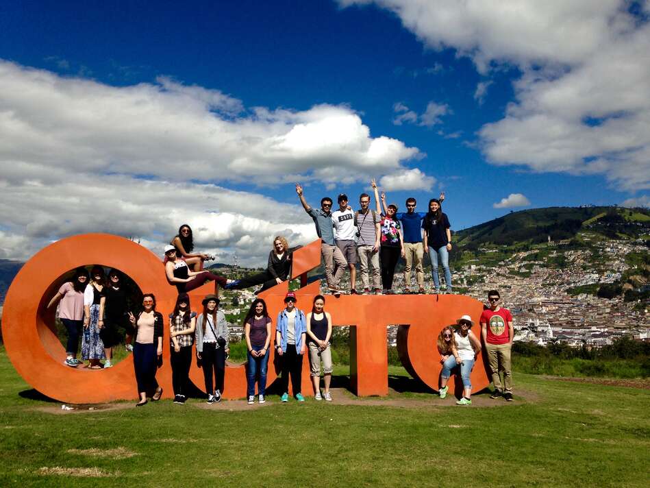 Students in front of a Quito sign.