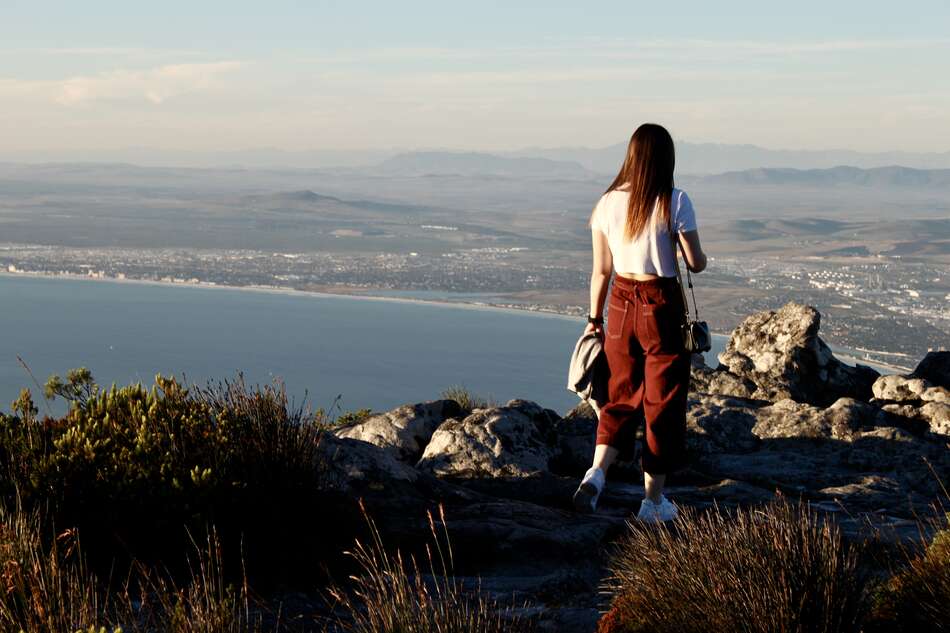 Student on mountain looking out to city and water