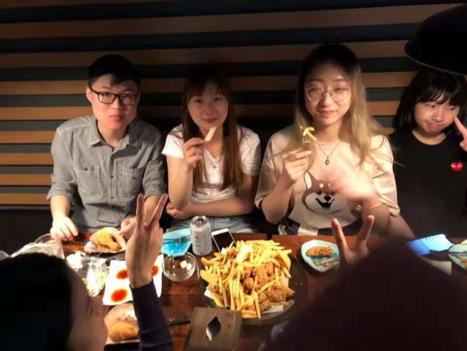 Four students at restaurant enjoying a meal together