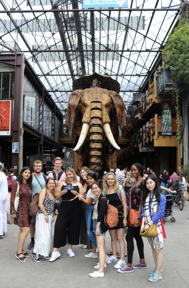 Group of students standing in front mechanical elephant