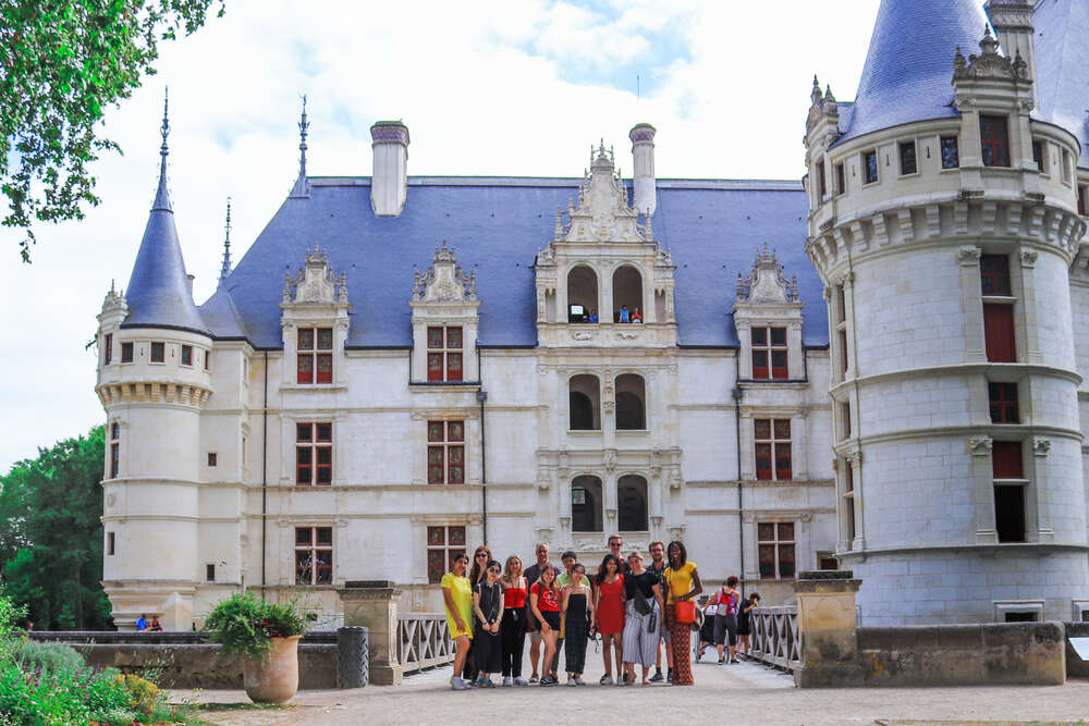 A group of students pose in front of a chateau in France